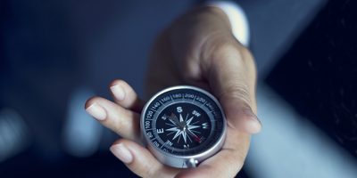 Businessman with a compass holding in hand, color tone film look